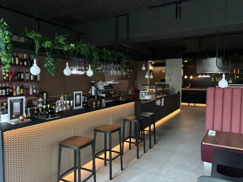 Bar im Fuego mit Barhockern, Pflanzen und beleuchteter Theke
